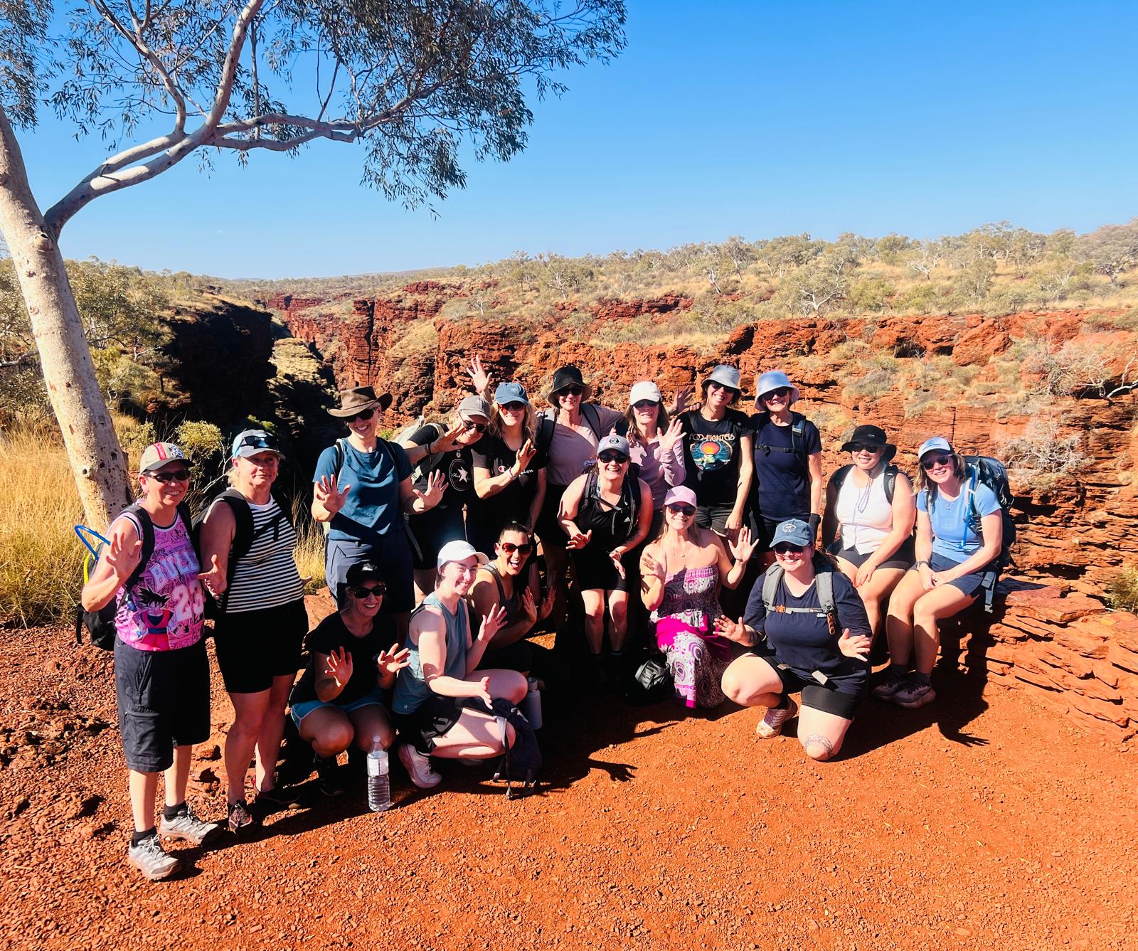 A group of Ladies HQ women posing together on a hike through a red rock gorge