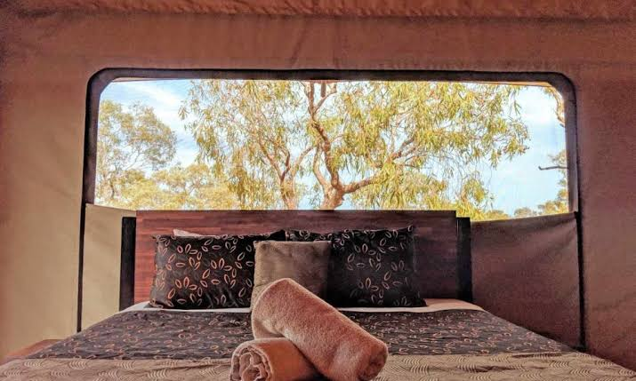 A queen bed inside an eco tent at Karijini Eco Retreat, from the Ladies HQ information pack